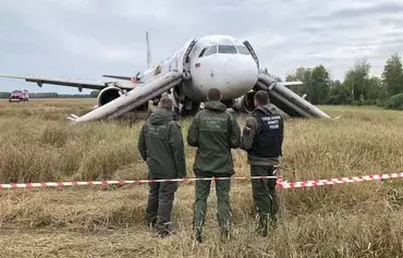 Российские следователи стоят рядом с пассажирским самолетом Airbus A320 авиакомпании «Уральские авиалинии», совершившим аварийную посадку в поле в районе села Каменка Новосибирской области, 12 сентября. [Владимир Николаев/AFP].