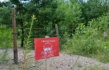 This photograph taken on July 14 shows a sign reading 'Attention mines' on the closed checkpoint of Slavutych on the Ukrainian-Belarusian border in Chernihiv province, amid the Russian invasion of Ukraine. [Sergei Supinsky/AFP]