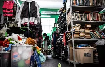 A woman looks at clothes at a humanitarian aid warehouse of the Lighthouse Charity Foundation (Mayak Fund) in Moscow on August 9. [Alexander Nemenov/AFP]