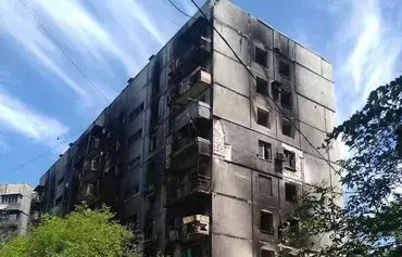 Shown is Gennady's apartment building, which was burned during the attack on Mariupol. The building went up in flames in summer 2022, but his apartment escaped damage. [Gennady's personal archive]