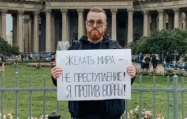 Artyom Belsky, 34, holds a poster that reads, "Wishing for peace is not a crime! I am against the war," near the Kazan Cathedral in St. Petersburg on September 30. [Photo provided to OVD-Info by eyewitnesses]