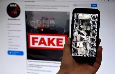 This illustration photo taken on February 14 shows a phone screen displaying a picture of rescuers working on a residential building destroyed after a missile strike, in Dnipro on January 16, 2023, with the WarOnFakes.com website displaying a fake video of the same residential building shown in the background. A Russian missile smashed a Ukrainian apartment complex, killing dozens. Pro-Russian propagandists offered a slick counter narrative that shifted the blame away from Moscow -- using pseudo fact-checking as a tool of disinformation. [Olivier Douliery/AFP]