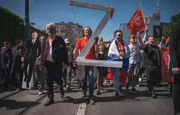 A man carries a giant letter 'Z,' which has become a symbol of support for the Russian invasion of Ukraine, during the 'Immortal Regiment' march in Belgrade, Serbia, on May 9, 2022. About 200 people took part in the march past the Russian embassy to mark the Soviet victory over the Nazis in 1945. [Andrej Isakovic/AFP]