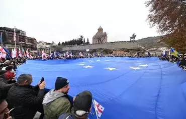 Грузины проводят марш в поддержку вступления в Евросоюз за несколько дней до того, как страна должна получить официальный статус кандидата на вступление в ЕС. Тбилиси, 9 декабря. [Вано Шламов/AFP]