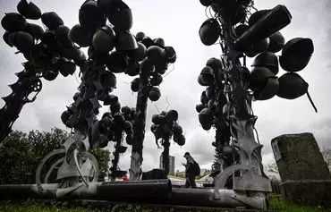 A man walks by a monument to late Russian soldiers made of helmets in the Museum of Russia's Armed Forces in Moscow on October 18. [Alexander Nemenov/AFP]