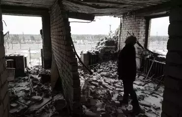 Lyubov Surzhan, 67, stands in her apartment that was destroyed during shelling in Lyman, Donetsk province, on December 9, amid the Russian invasion of Ukraine. For more than 20 months she has been living in a small room in the basement of her house. [Anatolii Stepanov/AFP]