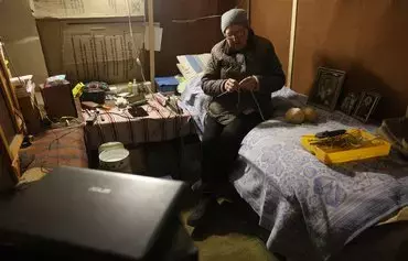 Lyubov Ganzhela, 63, sits in the basement of her house where she has been living since May 2022 in Lyman, Donetsk province, on December 9, amid the Russian invasion of Ukraine. [Anatolii Stepanov/AFP]