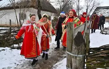 Women wearing traditional Ukrainian clothes take part in Christmas celebrations in the village of Pyrogove near Kyiv on December 25. [Sergei Supinsky/AFP]