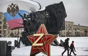 Pedestrians December 26 in Moscow walk past a New Year decoration -- a Kremlin star bearing the letter Z, a symbol of Russian troops in Ukraine, in front of a monument dedicated to heroes of World War I. [Alexander Nemenov/AFP]