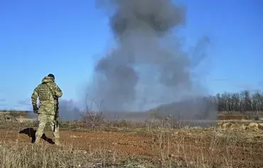 A Ukrainian sapper of the 22nd Separate Mechanized Brigade looks at smoke of an explosion during a military training exercise in Donetsk province last November 28, amid the Russian invasion of Ukraine. [Genya Savilov/AFP]