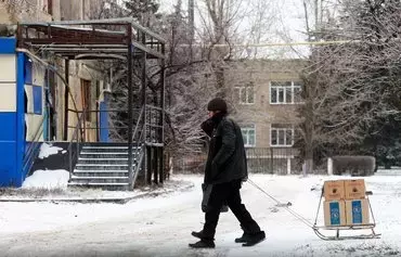 Local residents pull a sled with boxes of humanitarian aid in the town of Toretsk, Donetsk province, on December 14, amid the Russian invasion of Ukraine. [Anatolii Stepanov/AFP]