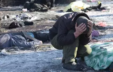 A man cries next to the dead body of his wife who was killed in a missile strike in Donetsk on January 21. [AFP]