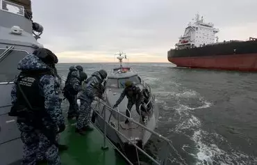 An inspection group of the State Border Service of Ukraine prepares to board a cargo ship for inspection for prohibited items and substances before entering a port in the northwestern part of the Black Sea, on December 18, amid the Russian invasion in Ukraine. [Anatolii Stepanov/AFP]