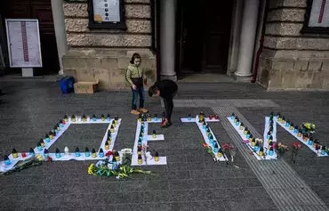 Candles are displayed on letters reading the word 'children' in Russian during a commemorative event in Lviv, Ukraine, last March 16 to mark the first anniversary of the bombing of the Mariupol Drama Theater amid the Russian invasion of Ukraine. The Mariupol Drama Theater, used as an air raid shelter, was bombed by Russian aircraft on March 16, 2022, as 'hundreds' of civilians took refuge in it. [Yuriy Dyachyshyn/AFP]