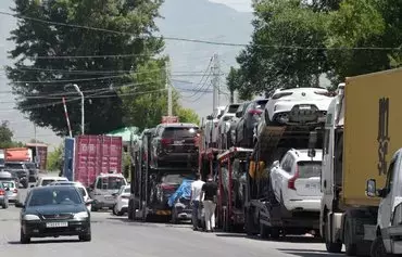 Used cars are seen on trailers outside a customs house in the Armenian town of Gyumri last July 20. While the United States and the European Union have banned the export of vehicles to Russia, cars may still be exported through Armenia. [Karen Minasyan/AFP]