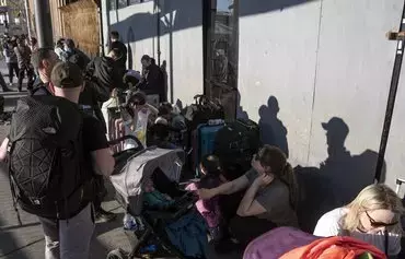 Asylum seekers from Ukraine March 24, 2022, in Tijuana, Mexico, wait for US border authorities to allow them entry. [Guillermo Arias/AFP]