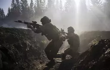 Instructors from the Norwegian Home Guard participate in a blank fire exercise, together with Ukrainian soldiers, in part of Operation Gungne. Norwegian instructors conducted initial training with NATO-standard combat methods to enhance Ukrainian military capabilities on August 25, north of Trondheim, Norway. [Jonathan Nackstrand/AFP]