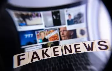 This illustration photograph shows letters reading 'fake news' seen through a magnifying glass, against a laptop screen displaying other illustration images of various alleged fake news, disinformation campaigns or conspiracy theories, in Mulhouse, France, on December 1. [Sebastien Bozon/AFP]