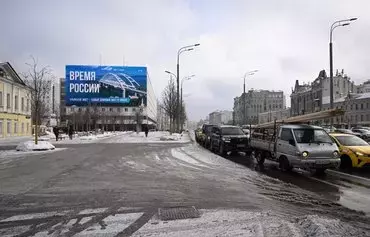 A giant screen displays an image of the Kerch bridge that links Crimea to Russia and the inscription 'Russia's time' in Moscow on February 13. [Natalia Kolesnikova/AFP]