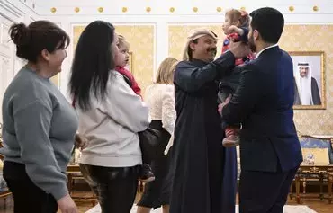 Qatari Ambassador to Russia Sheikh Ahmed bin Nasser Al Thani interacts with Ukrainian children before their departure to Ukraine from Russia under a deal brokered by Qatar at the Qatari embassy in Moscow on February 19. [Alexander Nemenov/AFP]