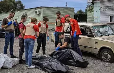 Members of the Red Cross check bodies of those killed by a missile strike near Zaporizhzhia on September 30, 2022, amid the Russian invasion of Ukraine. [Genya Savilov/AFP]