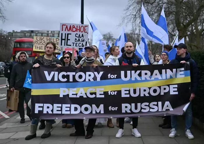 Demonstrators hold placards as they attend a protest march organised by the Russian Democratic Society, calling for an end to Russia's invasion of Ukraine, in London on February 25. [Justin Tallis/AFP]