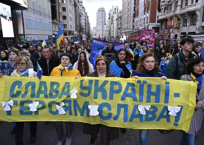 Demonstrators hold a banner reading 'Glory to Ukraine' as they march to support Ukraine and to mark the second year of Russia's invasion, in Madrid, Spain, on February 24. [Javier Soriano/AFP]