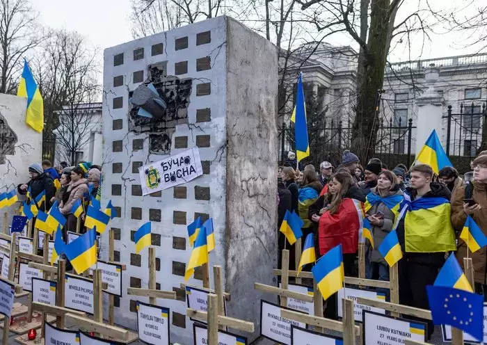 Demonstrators rally in support of Ukraine in front of the Russian embassy in Warsaw on February 24. [Wojtek Radwanski/AFP]