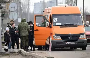 Military personnel from the breakaway Transnistria region of Moldova check the papers of individuals leaving the self-proclaimed republic at the Varnita crossing point on March 1. [Daniel Mihailescu/AFP]