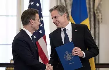 US Secretary of State Antony Blinken (right) receives the NATO ratification documents from Swedish Prime Minister Ulf Kristersson during a ceremony March 7 in Washington, DC, as Sweden formally joins the North Atlantic alliance. [Andrew Caballero-Reynolds/AFP]