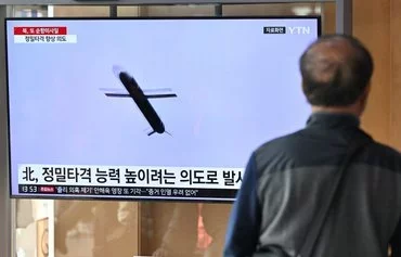 A man watches a television screen showing a news broadcast with file footage of a North Korean missile test, at a railway station in Seoul on February 2. [Jung Yeon-je/AFP]