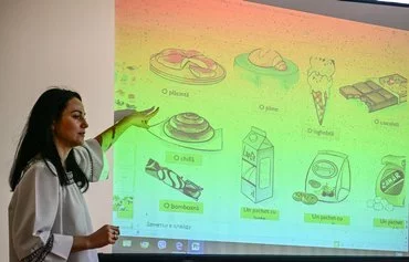 Romanian-language teacher Sorina Stoianova teaches her students the Romanian names of food during the free weekly Romanian-language lesson in Vulcanesti, Gagauzia, Moldova, on November 14. [Daniel Mihailescu/AFP]