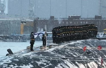 This pool photograph distributed by Russian state agency Sputnik shows the new Emperor Alexander III nuclear submarine during a flag-raising ceremony led by Russian President Vladimir Putin at the Arctic port of Severodvinsk last December 11. [Kirill Iodas/AFP]