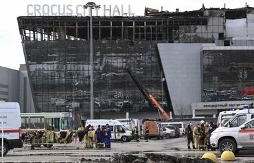 Emergency personnel work by the burnt-out Crocus City Hall concert venue in Krasnogorsk, outside Moscow, on March 26. [Natalia Kolesnikova/AFP]