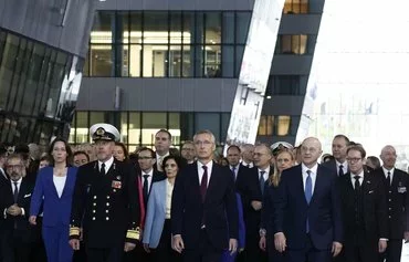 NATO Secretary General Jens Stoltenberg (center), accompanied by NATO Military Committee chairman and Dutch Adm. Rob Bauer (front left) and NATO Deputy Secretary General Mircea Geoana (front right) and international foreign ministers, attends the alliance's 75th anniversary celebration at NATO headquarters in Brussels on April 4. [Kenzo Tribouillard/AFP]