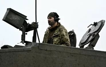 A Ukrainian serviceman of the 82nd Separate Air Assault Brigade prepares a Challenger 2 tank for combat in an undisclosed location near the front in Zaporizhzhia province, on February 12, amid the Russian invasion of Ukraine. [Genya Savilov/AFP]