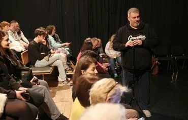 Theatre director Anatoliy Levchenko, 54, from Mariupol, stands among members of the audience before the premiere of his play 'Light at the End of the Tunnel' in Kyiv, on April 7. [Anatolii Stepanov/AFP]