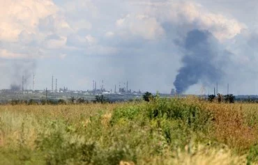 This photograph taken last July 12 shows smoke billowing over the oil refinery outside the town of Lysychansk occupied by Russian troops, in Luhansk province, Ukraine, amid the Russian invasion of Ukraine. [Anatolii Stepanov/AFP]