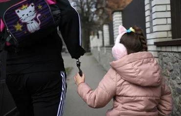 Kucherenko walks home with his elder daughter Valeria from her school in Bila Tserkva, on April 4, amid the Russian invasion in Ukraine. [Anatolii Stepanov/AFP