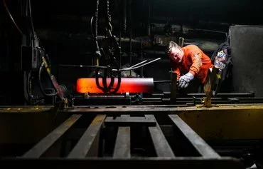 A worker inspects the form of the shaped steel billets following the 'press' stage in the manufacturing process of 155mm caliber shells at the Scranton Army Ammunition Plant (SCAAP) in Scranton, Pennsylvania, on April 16. [Charly Triballeau/AFP]