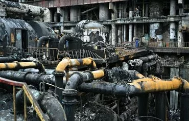 Workers clean up debris in a turbine hall full of scorched equipment at a power plant of energy provider DTEK, destroyed after an attack, in an undisclosed location in Ukraine on April 19, amid the Russian invasion of Ukraine. [Genya Savilov/AFP]