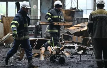 Rescuers and workers clean up debris in a turbine hall full of scorched equipment at a power plant of energy provider DTEK, destroyed after an attack, in an undisclosed location in Ukraine on April 19. [Genya Savilov/AFP]