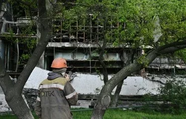 A worker makes a call in front of a turbine hall at a power plant of energy provider DTEK, destroyed after an attack, in an undisclosed location in Ukraine on April 19. [Genya Savilov/AFP]