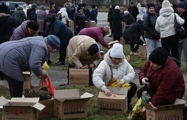 Internally displaced civilians receive humanitarian aid distributed in Zaporizhzhia on February 6, amid the Russian invasion of Ukraine. [Andriy Andriyenko/AFP]