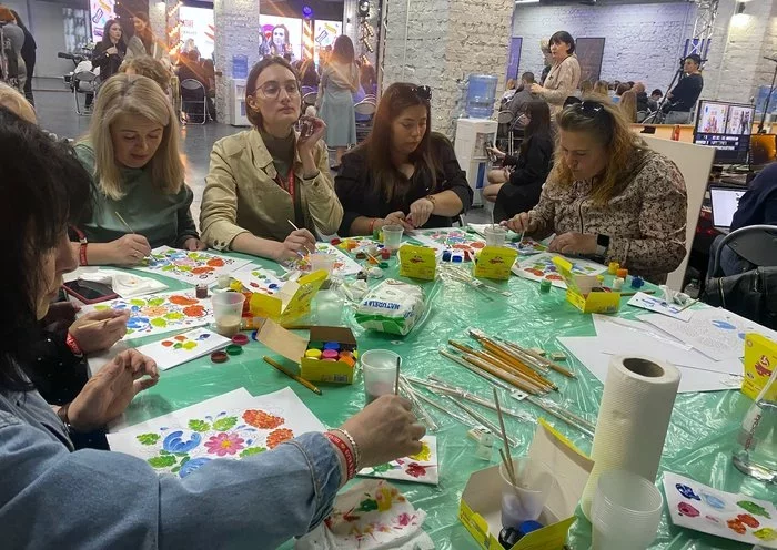 At the Proud to be Ukrainian festival on April 20 in Zaporizhzhia, women draw flowers in a Ukrainian folk ornamental style known as Petrykivka painting. [Olha Chepil/Kontur]