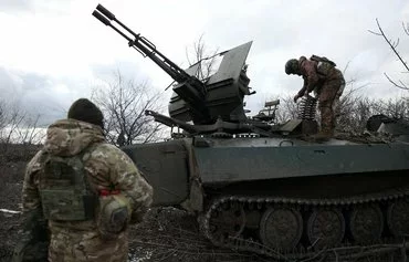 Ukrainian anti-aircraft gunners of the 93rd Separate Mechanized Brigade Kholodny Yar equip weapons from their positions in the direction of Bakhmut in Donetsk province, amid the Russian invasion of Ukraine, on February 20. The EU has committed to using frozen Russian banking profits to arm Ukraine. [Anatolii Stepanov/AFP]