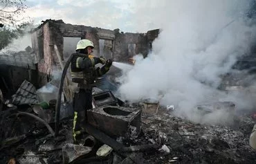 Firefighters put out a fire in a private house after a Russian drone attack in the suburbs of Kharkiv, on May 21 amid the Russian invasion in Ukraine. [Sergey Bobok/AFP]