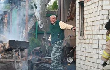 Local residents inspect the remains of their destroyed house after a Russian drone attack in the suburbs of Kharkiv, on May 21. [Sergey Bobok/AFP]