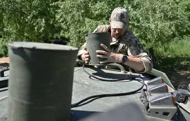 Ukrainian serviceman Mykola, 42, a jammer specialist, sets an antenna of a drone signal jamming system on an armored four-wheel-drive vehicle in an undisclosed location in Donetsk province April 30. [Genya Savilov/AFP]