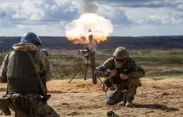 Ukrainian soldiers fire a mortar during military training with French servicemen at an undisclosed location in Poland. [Wojtek Radwanski/AFP]